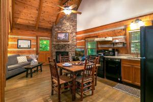 a kitchen and dining room with a table and a fireplace at Dancing Bear Lodge in Townsend