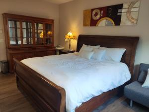 a bedroom with a large bed and a chair at Two Bedroom Suite with Private Bathroom and Shared Lounge in West Kelowna