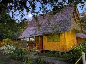a small yellow house with a thatched roof at Yarina Eco Lodge in Derna