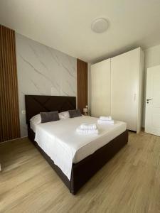 ein Schlafzimmer mit einem großen Bett mit zwei Handtüchern darauf in der Unterkunft Waterfront Apartments in Durrës