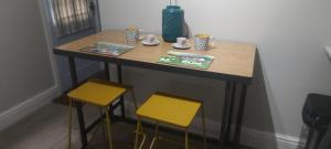een kleine tafel met twee stoelen en een tafel met kopjes bij 1 Courtyard Mews in Penzance