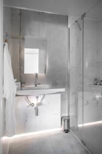 a white bathroom with a sink and a shower at Chalet Zenspace in Le Grand-Bornand