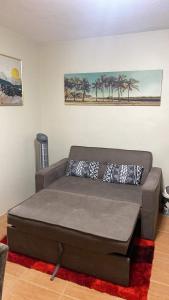 a brown couch in a living room with palm trees at Affordable 2 bedroom condo unit in Cagayan de Oro