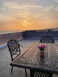 einen Tisch und Stühle auf einem Balkon mit Meerblick in der Unterkunft ALHOULY CHALIt in Sur