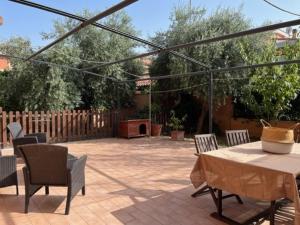 un patio con mesa, sillas y una valla en Garden House Ciampino, en Ciampino