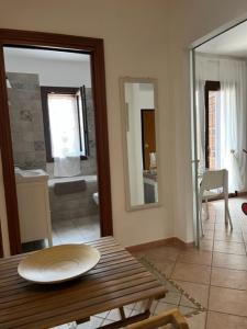 Habitación con mesa y baño con bañera. en Garden House Ciampino, en Ciampino