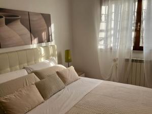 białe łóżko w białej sypialni z oknem w obiekcie Garden House Ciampino w Ciampino