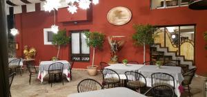 un restaurant avec des tables et des chaises et un mur rouge dans l'établissement Posada Real de Chiapas, à San Cristóbal de Las Casas