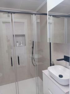 a white bathroom with a shower and a sink at Apartamento Santiago de La Ribera in Santiago de la Ribera