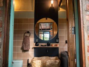 Habitación con baño con espejo y lavabo. en La Casita del Bosque, Minicasa totalmente equipada, con tina y agua caliente en Barichara