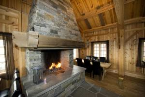 a living room with a stone fireplace in a cabin at Grindastugu cabin right by Liatoppen Ski Centre. in Al