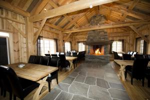 a dining room with tables and a fireplace at Grindastugu cabin right by Liatoppen Ski Centre. in Al