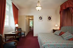 une chambre d'hôtel avec un lit, une table et des chaises dans l'établissement Château de Bellecroix, à Chagny