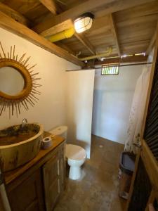 y baño con lavabo, aseo y espejo. en Cabañas roble verde, en Rincón