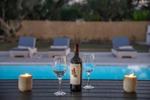 a bottle of wine and two wine glasses on a table at Ionian Escape in Zakynthos Town