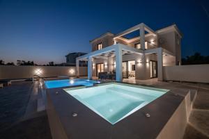 a villa with a swimming pool at night at Ionian Escape in Zakynthos