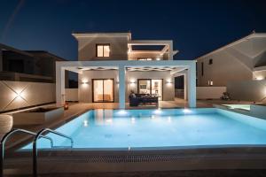 a large pool in front of a house at night at Ionian Escape in Zakynthos