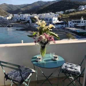 a table with a vase of flowers on a balcony at Apollon Sunrise in Apollon