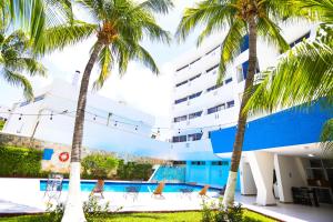 un hotel con palmeras y una piscina en Hotel Caribe Internacional Cancun en Cancún