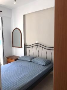 um quarto com uma cama com um cobertor azul e um espelho em Apollon Sunrise em Apollon