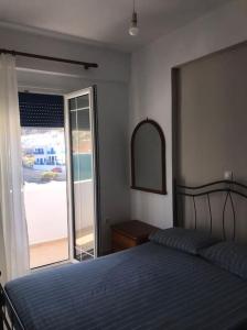 um quarto com uma cama e uma porta de vidro deslizante em Apollon Sunrise em Apollon