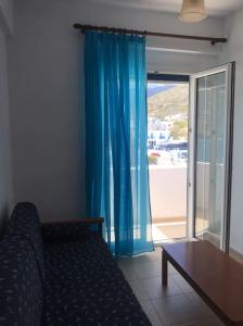 a living room with a couch and a blue curtain at Apollon Sunrise in Apollon