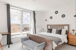 Un dormitorio con una cama y una silla y una ventana. en A Modern Lavish En-suite Bedroom, en Londres