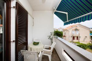 a balcony with a table and chairs and an umbrella at Nada in Krk