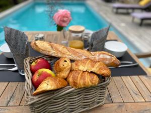 a basket of bread and apples on a table at appartement indépendant avec piscine in Saint-Prix