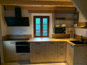 a kitchen with wooden cabinets and a window at Apartma Povlč in Poljane nad Škofjo Loko