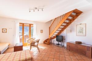 a living room with a staircase and a television at Chalet Clos Gauthier in La Salle Les Alpes