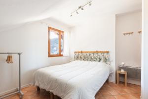 Un dormitorio blanco con una cama y una ventana. en Chalet Clos Gauthier, en La Salle-les-Alpes