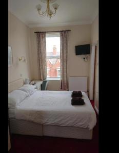 a bedroom with a white bed and a window at Viking Hotel in Bridlington