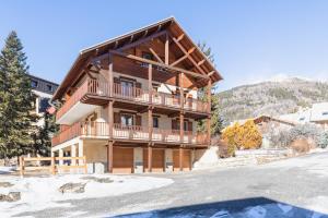 a large wooden house with a balcony at Chalet Clos Gauthier in La Salle-les-Alpes