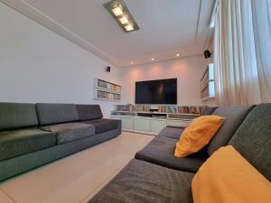 sala de estar con sofá y TV de pantalla plana en Palace Residence, en Garanhuns