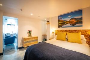 1 dormitorio con 1 cama con almohadas amarillas en Brand New Apartment Central Location Hot Tub en Bowness-on-Windermere