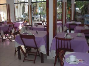 a dining room with purple tables and chairs at Hotel Palmas del Sol in Asunción
