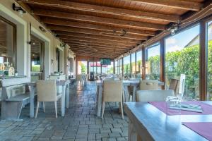 un restaurante con mesas, sillas y ventanas en Fortebraccio, en Montone