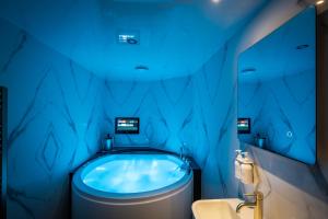 een badkamer met een blauw bad en een wastafel bij Brand New Apartment Central Location Hot Tub in Bowness-on-Windermere