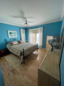 尚博爾的住宿－Les pieds dans le sable，一间卧室设有一张蓝色墙壁和天花板的床。