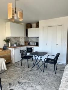 uma cozinha com mesa e cadeiras num quarto em Studio cosy avec terrasse sur la plage em La Seyne-sur-Mer