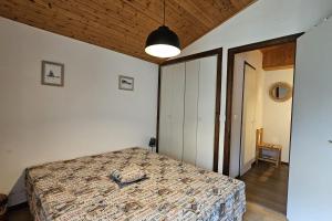 a bedroom with a bed and a wooden ceiling at 3-star apartment with view in La Clusaz