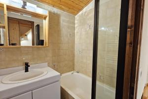 a bathroom with a sink and a bath tub at 3-star apartment with view in La Clusaz