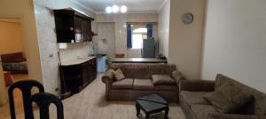 a living room with a couch and a kitchen at شاليه ٢٩ لا ارضي غرفتين اللوتس الساحل الشمالى in El Alamein