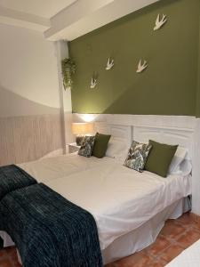a bedroom with a large white bed with green walls at Close to Sierra Nevada Casa Con Chimenea y Parking Las Golondrinas in Güéjar-Sierra