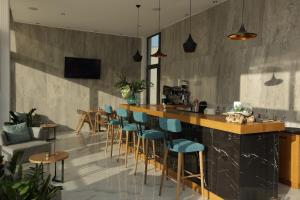 a bar in a restaurant with blue stools at Ellin Hotel in Kallithea Halkidikis