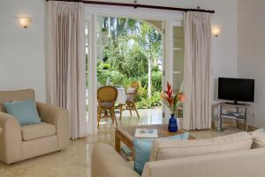 a living room with a couch and a tv and a table at Sunny Vacation Villas No 14 in Saint Peter