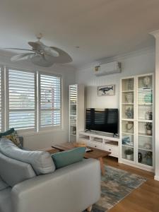 ein Wohnzimmer mit einem Sofa und einem Flachbild-TV in der Unterkunft Bluemoon Getaway in Catherine Hill Bay