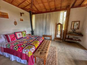 1 dormitorio con cama, mesa y espejo en Mirante do Espinhaço, en Itabirito