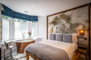 a bedroom with a bed and a bath tub next to a window at Glen Wynne Recently Renovated - FREE off-site Health Club access with Pool, Sauna, Steam Room & Gym Short 5 Minute Drive Away in Windermere
